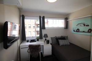 a living room with a couch and a tv and a window at Kongensgate Apartments in Kristiansand