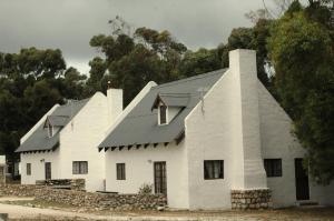 a large white building with a black roof at Juffroushoogte Gaste Plaas in Vredenburg