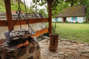 - un grill suspendu au-dessus d'un feu dans une arrière-cour dans l'établissement Siedlisko olenderskie na Mazowszu, à Łady