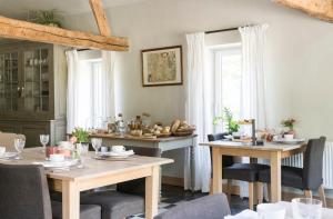 a dining room with tables and chairs and a window at B&B Het Soetewater in Beernem
