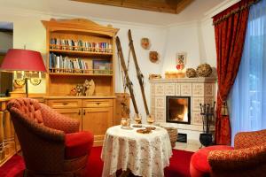 a living room with a table and chairs and a fireplace at Hotel Gries in Canazei