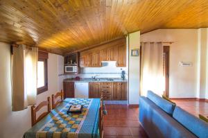 a kitchen with a table and a blue couch at Apartamentos Rurales El Prado in Pinofranqueado