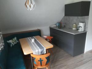 una pequeña cocina con una mesa de madera y una encimera en Haus Anneliese, en Pruggern