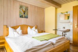 ein Schlafzimmer mit einem großen weißen Bett und einem Waschbecken in der Unterkunft Bio Bauernhof Oberbenk in Wagrain