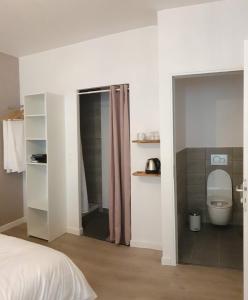 Chambres privées hyper-centre Epernay lit 160x200cm في إيبيرني: غرفة نوم بسرير وحمام مع مرحاض