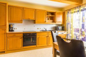 a kitchen with wooden cabinets and a stove top oven at Bio Bauernhof Oberbenk in Wagrain