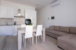 a kitchen and living room with a table and a couch at Le bougainvillea 2 in Corbetta
