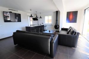 sala de estar con 2 sofás negros y cocina en Hoyo 19, en Marbella