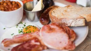 a plate of breakfast food with eggs bacon and toast at Accommodation At Thabong in Brakpan