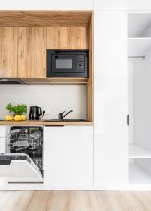 a kitchen with a microwave and a dishwasher at Yellow House Dziwnów in Dziwnów