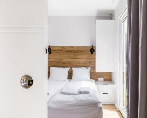 una camera da letto bianca con un letto e una finestra di Yellow House Dziwnów a Dziwnów
