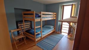 a bunk bed room with two bunk beds and a desk at Ostello del Parco di Cicogna in Cicogna