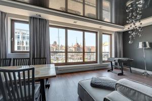 salon z kanapą, stołem i oknami w obiekcie Blue Mandarin Marina w Gdańsku