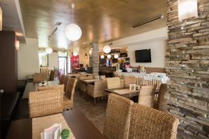 a restaurant with tables and chairs and a stone wall at Къща за гости Екстаси in Primorsko