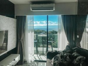 バンサレーにあるDeamber Bangsare Pattayaのベッドルーム1室(海の景色を望む大きな窓付)