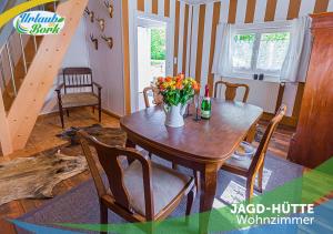 a dining room table with a vase of flowers on it at Jagd-Angler-Holzhaus-im-Wald-am-See in Kyritz