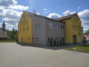 ein gelbes und weißes Gebäude auf einer Straße in der Unterkunft Centrum pro vzdělávání a kulturu in Nový Oldřichov