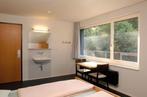 bagno con lavandino, finestra e scrivania di Baden Youth Hostel a Baden