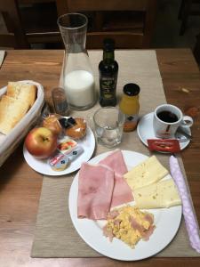 una mesa con dos platos de comida y leche en Hostel La Huertica, en Valtierra