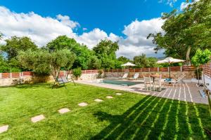 a backyard with a swimming pool and a lawn at Villa Archontiki I - Private Pool in Vryses