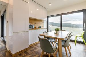 a kitchen and dining room with a table and chairs at Mountain view apartment in Loučná pod Klínovcem