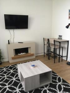 a living room with a fireplace and a table with chairs at The garden flat in Torquay