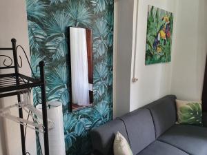 salon z kanapą i lustrem w obiekcie Urban Suites w mieście Aveiro