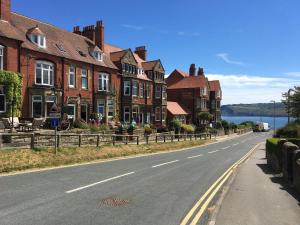een straat met huizen aan de kant van een weg bij West Royd in Robin Hood's Bay +9 foto's