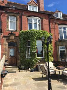 een stenen huis met een groene klimop erop bij West Royd in Robin Hood's Bay