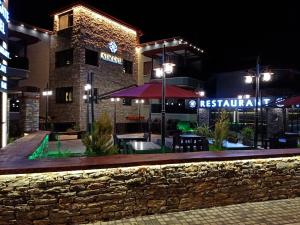 a restaurant at night with a brick building at SARIGERME NEW GATE HOTEL in Sarigerme