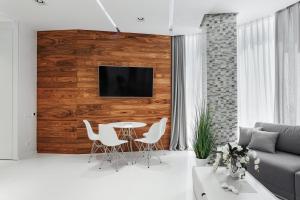a living room with a table and a tv on a wall at Feeria Apartment in Odesa
