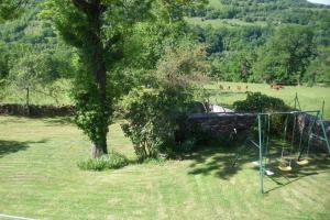 a swing set in a field with a tree at LA TRUFFIERE in Castelnau-de-Mandailles +7 photos