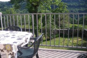 a table and chairs on a deck with a fence at LA TRUFFIERE in Castelnau-de-Mandailles