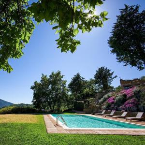 a swimming pool with lounge chairs in a yard at Incantico "Eco Resort" in Assisi