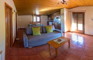 sala de estar con sofá azul y mesa en Apartamentos Rurales El Prado en Pinofranqueado