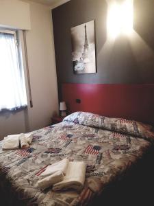 łóżko z ręcznikami i wieżą Eiffel w obiekcie Hotel La Torre w mieście Cogoleto