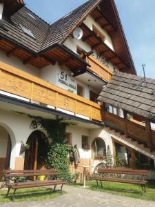 un edificio con dos bancos delante en Willa u Kośle Zakopane en Zakopane