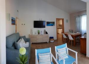 a living room with a blue couch and chairs at Villa Desi in Cala en Blanes