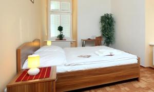 a bedroom with a bed and a table with a lamp at Pension Wallis in Pilsen