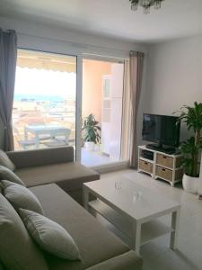 a living room with a couch and a tv at Charmant 2P Vue Mer face au Port de Golfe Juan in Golfe-Juan
