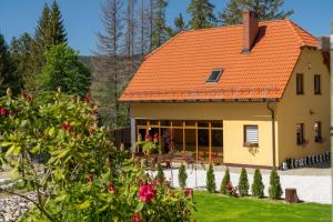 a house with an orange roof and some flowers at Dom Myśliwski in Szklarska Poręba