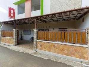 - l'entrée d'un bâtiment avec une porte en bois dans l'établissement Super OYO 3314 Syariah House, à Purwokerto