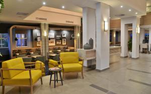 a lobby with yellow chairs and a bar at Town Lodge Menlo Park in Pretoria
