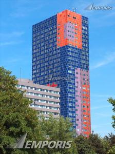 a tall orange and blue building with trees in front of it at Studio-Apartment, zentral gelegen in Cologne