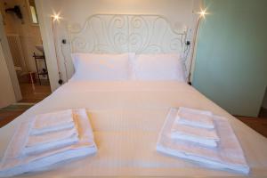 a bed with a white comforter and pillows at Il Podere Degli Artisti in San Casciano dei Bagni