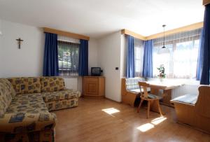 a living room with a couch and a table at Apartments Nadia in San Vigilio Di Marebbe