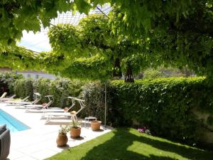 een tuin met ligstoelen en een zwembad bij HÖTEL LE CASTELLAN in Istres