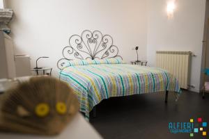 ナポリにあるCasa Vacanze Alfieriのベッドルーム1室(カラフルな毛布付きのベッド1台付)