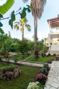 un jardin avec des palmiers et des fleurs dans l'établissement Christa Luxury Apartments, à Kavos