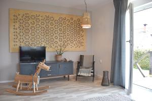 a living room with a tv and a toy giraffe at Lesnavesna designer Apartment with a garden in Visoko
